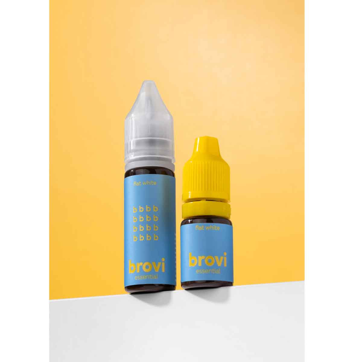 Two Brovi e-liquid bottles standing upright on a white surface against a yellow-orange gradient background. The bottle on the left is taller, has a clear cap, and a blue label with yellow text reading 'brovi' and 'e-liquid'; the bottle on the right is shorter, has a bright yellow cap, and a matching blue label.