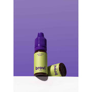 A bottle of Brovi One e-liquid in the 'warm dark brown' flavor, standing upright next to its cap on a white surface against a solid purple background.
