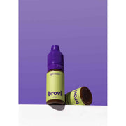 A bottle of Brovi One e-liquid in 'light brown' flavor, standing upright with its cap on, and another bottle lying on its side. The bottles have lime green labels and purple caps, set against a solid purple background with a white surface below.