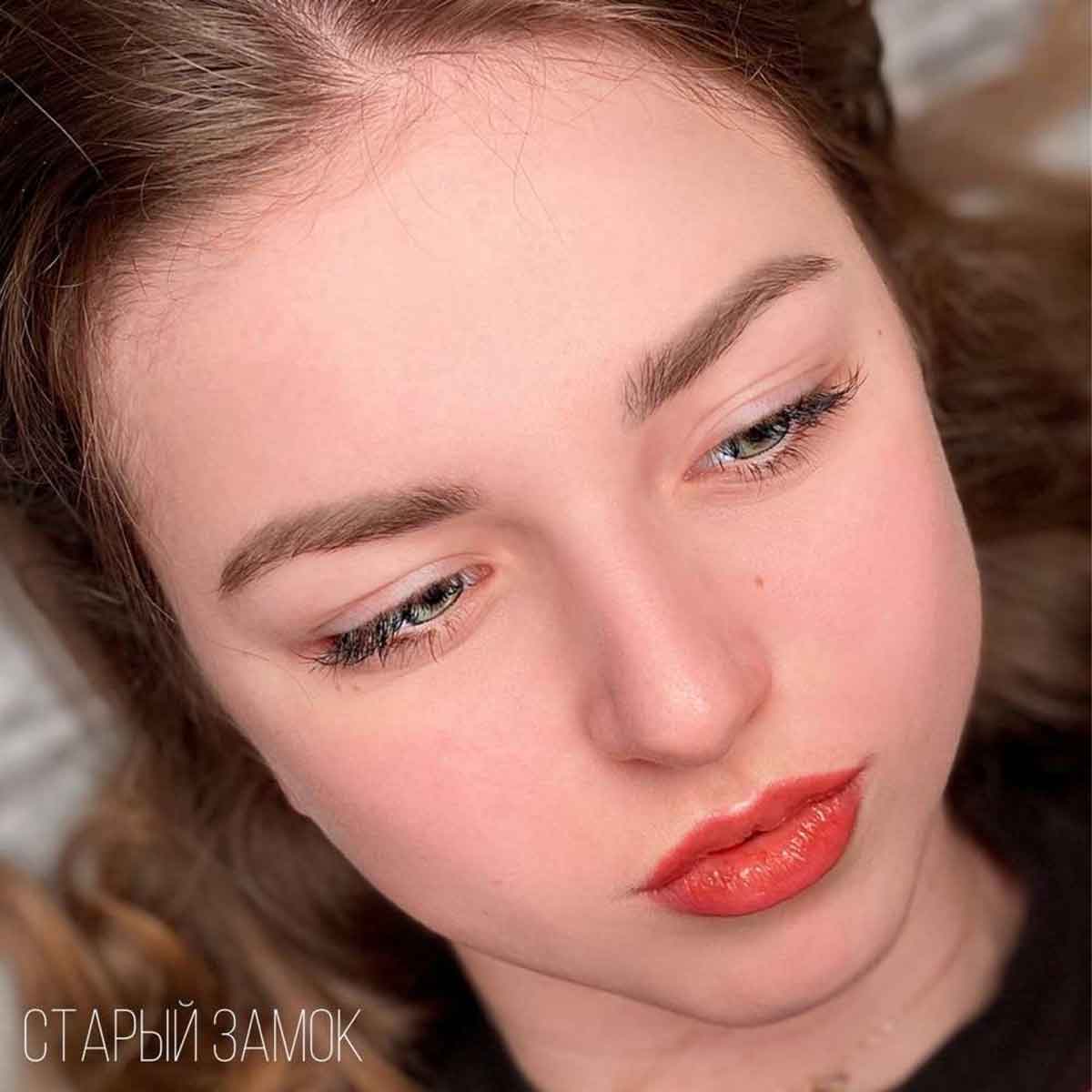 Close-up of a young woman with light brown hair wearing a coral-red lipstick, looking down. The text 'СТАРЫЙ ЗАМОК' is visible in the bottom-left corner.