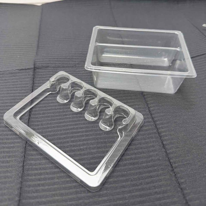 Tattoo tray mold with wavy design on a textured black surface