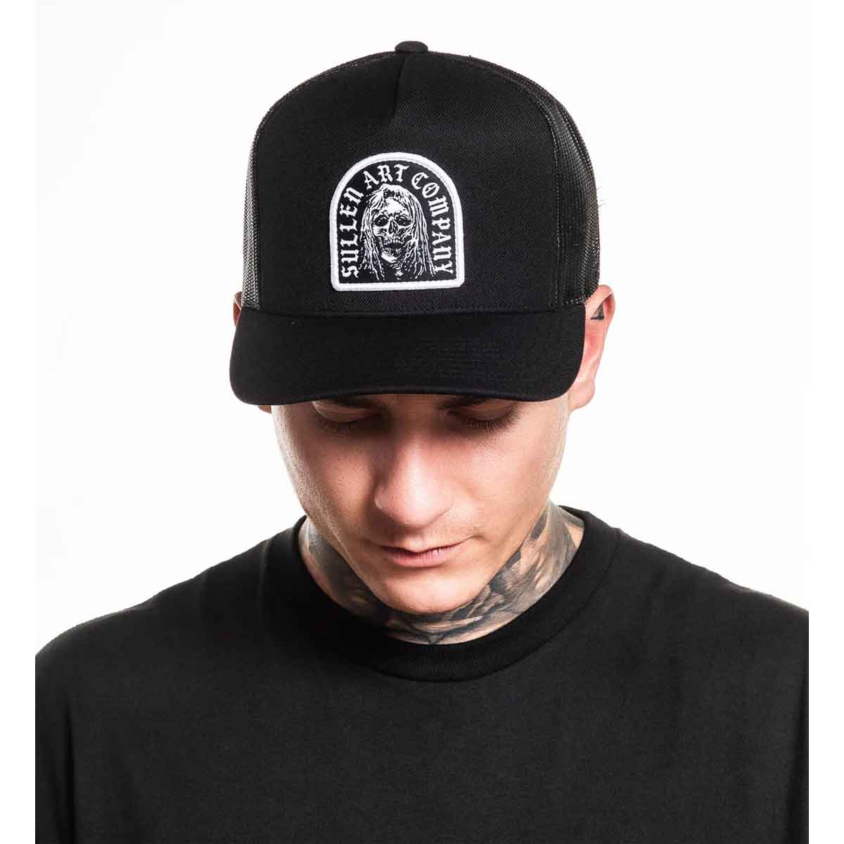 Person wearing a black cap with a logo on a white background