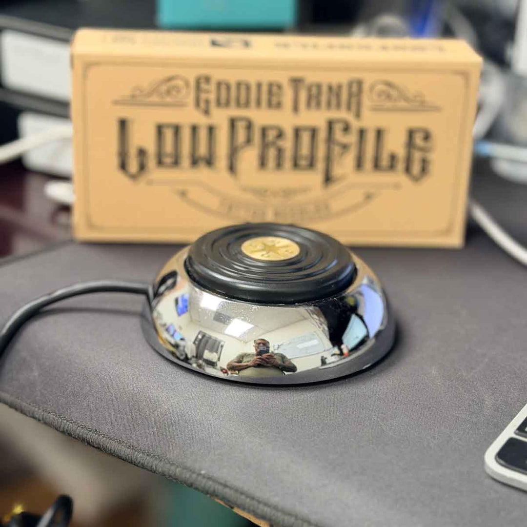 tattoo foot switch on a surface with 'Eddie Tan Low Profile' packaging in the background