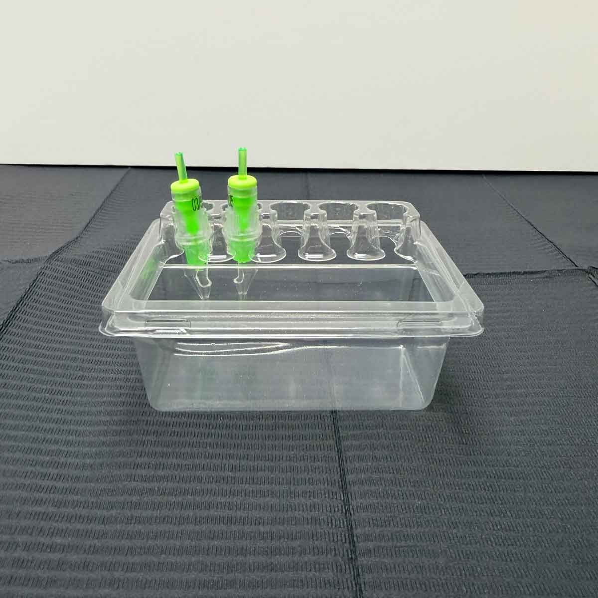 tattoo cartridge tray with green nozzles on a gray surface